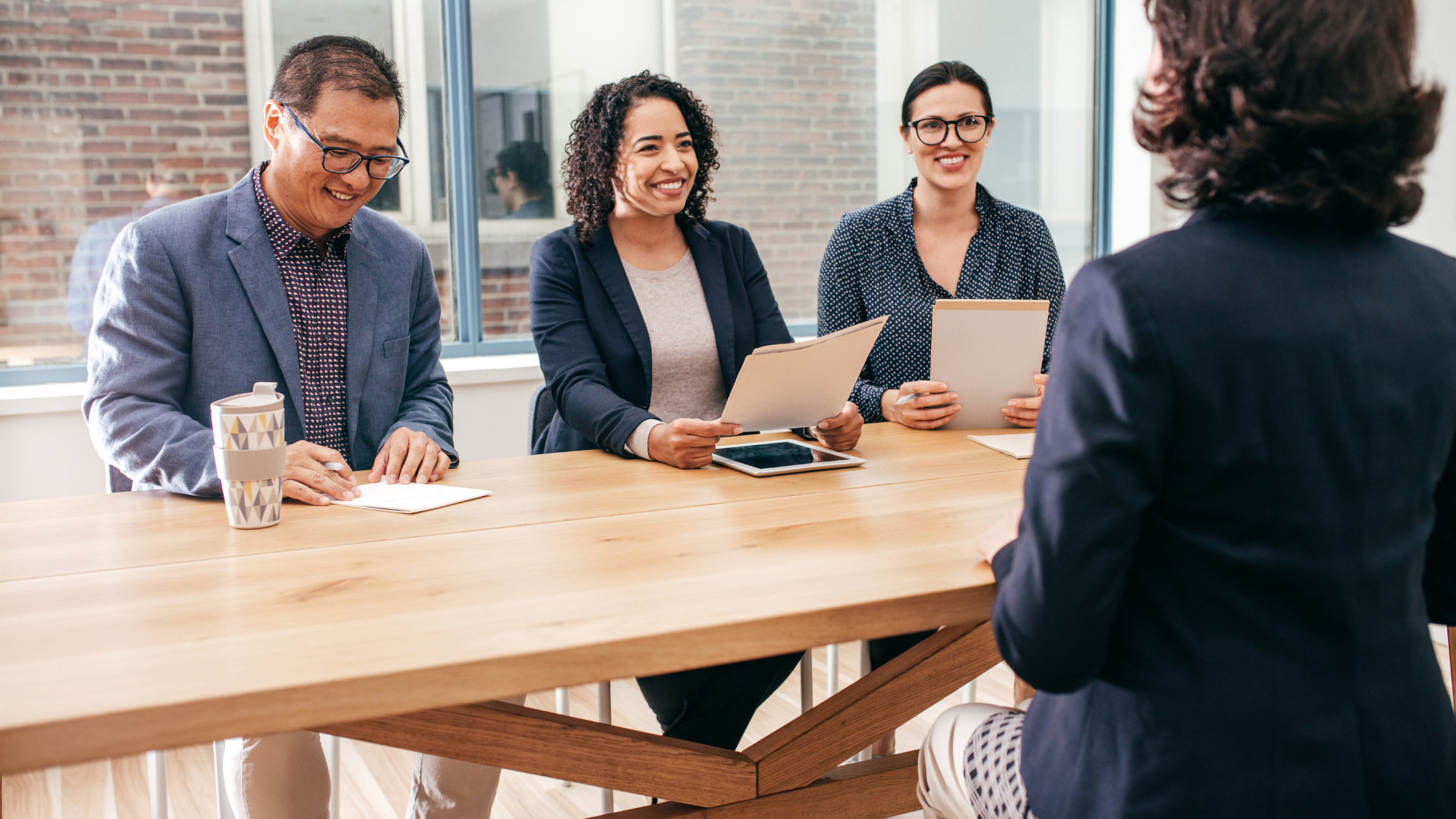 3 people interviewing another person